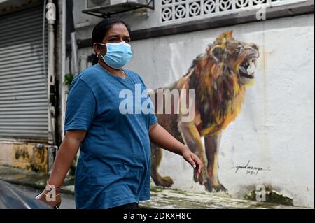 Kuala Lumpur, Malaysia. Dezember 2020. Eine Frau mit Gesichtsmaske geht auf einer Straße in Klang des Staates Selangor, Malaysia, 16. Dezember 2020. Malaysia meldete 1,295 neue COVID-19-Infektionen, teilte das Gesundheitsministerium am Mittwoch mit und brachte die nationale Gesamtzahl auf 87,913. Quelle: Chong Voon Chung/Xinhua/Alamy Live News Stockfoto