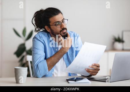 Junge Arabische Männliche Unternehmer Arbeiten Mit Papieren Am Schreibtisch In Büro Stockfoto