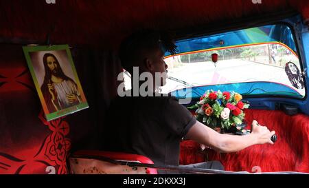 Lalibela-Äthiopien - 12. April 2019: Rikscha-Fahrer mit Bildern von Jesus Christus und Bob Marley Stockfoto