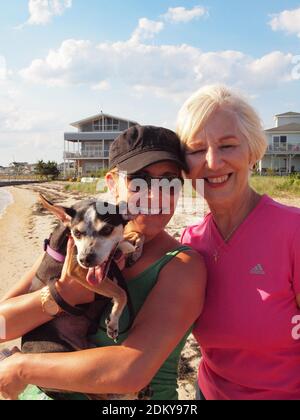 Besitzer und ihre Mutter mit Rattenterrier entlang der New Jersey Küste im Sommer genießen die Wärme und Sonne. Stockfoto