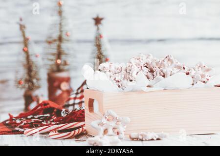 Hausgemachte weiße Schokolade oder Joghurt bedeckt Brezeln mit Stücken von zerkleinerten Zuckerrohr. Selektiver Fokus mit verschwommenem Vorder- und Hintergrund. Herz s Stockfoto