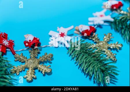 Weihnachtskomposition. Girlande aus goldenen Schneeflocken und Tannenzweigen auf blauem Hintergrund. Weihnachten, Winter, Neujahr Konzept. Stockfoto