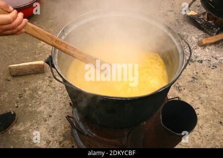 Vrancea County, Rumänien. Kochen Polenta im Freien in großen Kessel über Feuer. Stockfoto