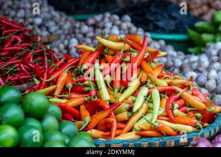 Orange, gelbe und rote Paprika zum Verkauf auf dem Street Food Markt in der Altstadt von Hanoi, Vietnam. Nahaufnahme Stockfoto