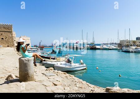 Fröhliches Touristenmädchen im venezianischen Hafen von Heraklion. Schöne stilvolle Mädchen in türkisfarbenem Kleid, entspannend lächelnd der Freude auf Urlaub Reise nach Kreta. Mädchen Stockfoto