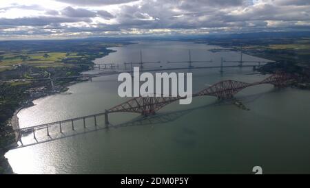 Eine Luftaufnahme über den firth of Forth und die historischen Brücken, die Fife und Edinburgh verbinden, und die neue Queensferry-Überfahrt im Bau. Stockfoto