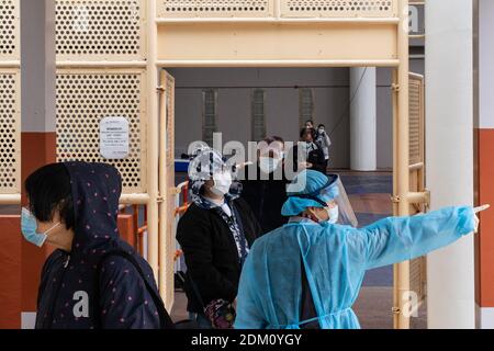 Hongkong, China. Dezember 2020. Ein Arzt, der eine persönliche Schutzausrüstung trägt, sah, wie er die Bewohner während der Tests unterstützte.die Regierung Hongkongs hat die temporären Testzentren eingerichtet, um die (COVID-19) für die Bewohner kostenlos testen zu können, da die Stadt der vierten Welle von Fällen gegenübersteht. Kredit: SOPA Images Limited/Alamy Live Nachrichten Stockfoto