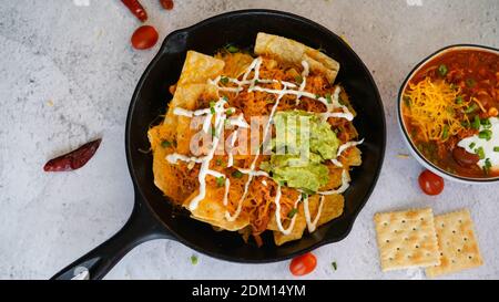 Skillet Türkei Chili Nachos gekrönt mit Sauerrahm und Guacamole Stockfoto