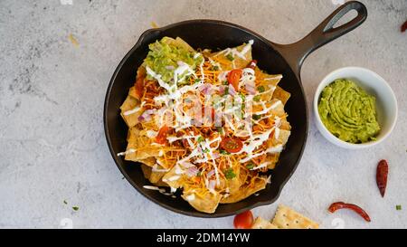 Skillet Türkei Chili Nachos gekrönt mit Sauerrahm und Guacamole Stockfoto