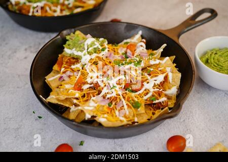 Skillet Türkei Chili Nachos gekrönt mit Sauerrahm und Guacamole Stockfoto