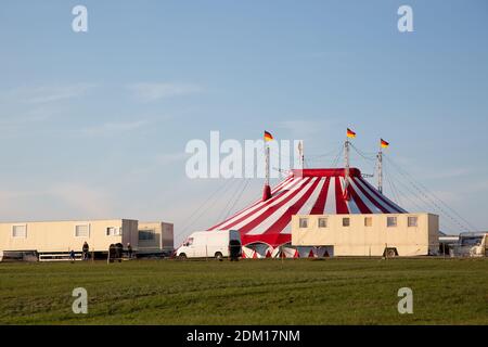 Ein Zirkus mit einem roten und whote Zelt an der Seite einer Landstraße. Stockfoto