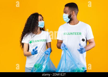 Zwei Freiwillige Halten Plastikflaschen Und Beutel Stehen Im Studio Stockfoto