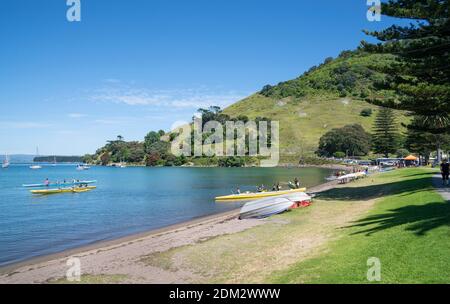 Tauranga Neuseeland - 2. Dezember 2020; Pilot Bay am Fuße des Mount Maunganui mit aktiven Menschen paddeln Waka-ama an schönen Sommertagen. Stockfoto