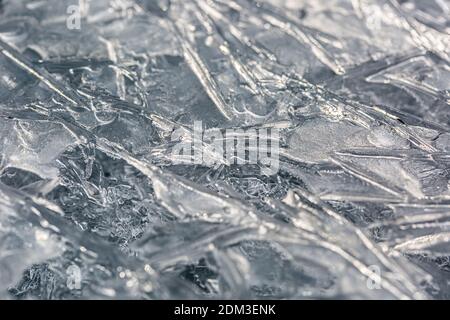 Nahaufnahme einer gefrorenen Wasseroberfläche im Winter. Gefrorene Eisstruktur. Eishintergrund für weihnachten. Gefrorener Fluss in der Schweiz aufgenommen. Stockfoto