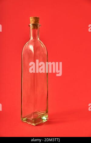 Leere Glasflasche mit Originalformen auf einem soliden neutralen Hintergrund. Studiobeleuchtung. Konzept für Werbung mit Platz für Zeichen oder Edition Stockfoto