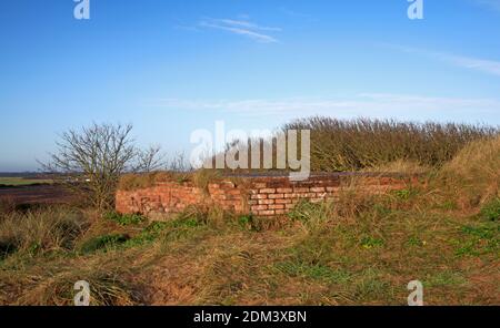 Die Spitze einer sechseckigen Pillendose des Typs 22 aus dem Zweiten Weltkrieg, die fast vollständig in Sanddünen in Waxham, Norfolk, England, Vereinigtes Königreich, vergraben ist. Stockfoto