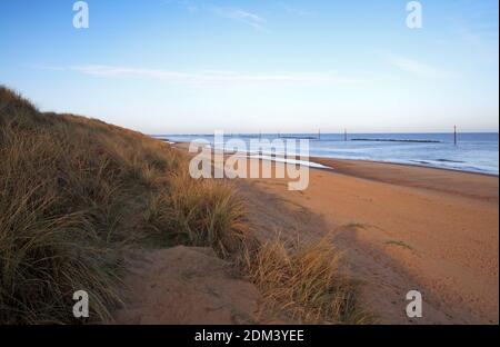 Ein Blick auf die Sanddünen, den Strand und das Meer an einem frühen Dezembermorgen in Waxham, Norfolk, England, Großbritannien.