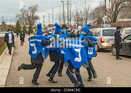 Southfield, Michigan - Jungen tanzen, während sich Autos für eine Car Top Menorah Parade am vierten Abend von Chanukah anstellen. Stockfoto