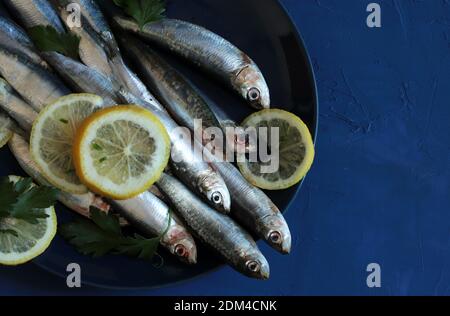 Fresh raw sardines on blue background. Top view. Stock Photo