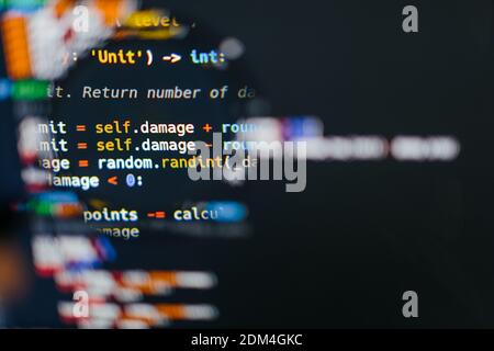 Programmcode auf dem Computerdisplay in der Lupe. Nahaufnahme. Hochwertige Fotos Stockfoto