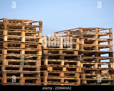 Stapel von Holzpaletten vor einem blauen Himmel Stockfoto