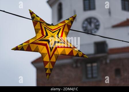 Lublin, Poland - December 29, 2019: Colorful illuminated star as Christmas decoration with Cracow Gate (Brama Krakowska) as background Stock Photo