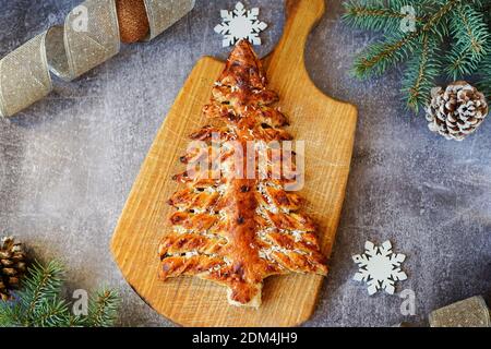 Torte in weihnachtsbaumform auf grauem Hintergrund mit Tanne Äste und Dekorationen Stockfoto