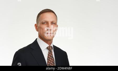 Confidence and success. Well looking man in suit and tie looking at camera while standing against white background. Stockfoto