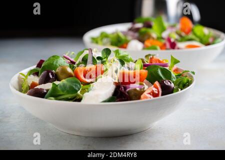Frischer grüner Salat mit Kirschtomate, Mozzarella und Oliven. Stockfoto