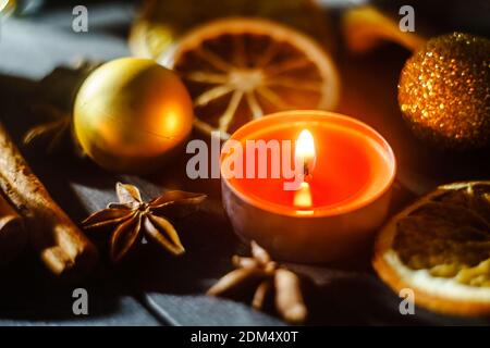 Weihnachtskomposition mit getrockneten Früchten, Gewürzen und brennender Kerze Stockfoto