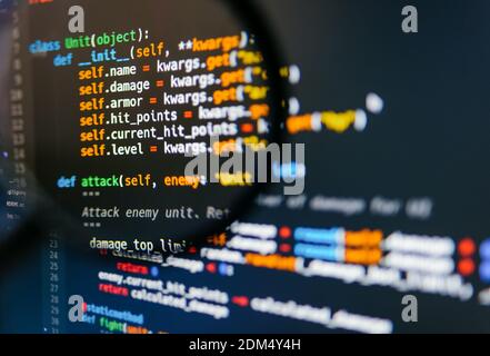 Programmcode auf dem Computerdisplay in der Lupe. Nahaufnahme. Hochwertige Fotos Stockfoto