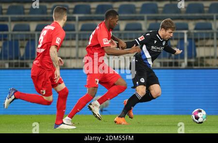 Bielefeld, Deutschland. Dezember 2020. Fußball: Bundesliga, Arminia Bielefeld - FC Augsburg, Matchday 12 in der Schüco Arena. Bielefelds Sven Schipplock (r) kämpft mit Augsburgs Jeffrey Gouweleeuw (l) und Reece Oxford um den Ball. Quelle: Friso Gentsch/dpa - WICHTIGER HINWEIS: Gemäß den Bestimmungen der DFL Deutsche Fußball Liga und/oder des DFB Deutscher Fußball-Bund ist es untersagt, im Stadion und/oder des Spiels aufgenommene Fotos in Form von Sequenzbildern und/oder videoähnlichen Fotoserien zu verwenden oder zu verwenden./dpa/Alamy Live News Stockfoto