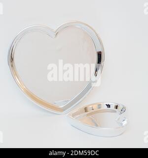 Eine vertikale Aufnahme von herzförmigen Platten isoliert auf einem weißen ba Stockfoto