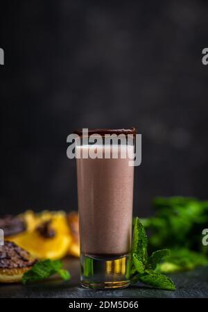 Alkoholcocktail in Schrotglas mit Schokoladenlikör, Wodka, Orangen und Minzblättern. Selektiver Fokus. Geringe Schärfentiefe. Stockfoto