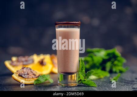 Alkoholcocktail in Schrotglas mit Schokoladenlikör, Wodka, Orangen und Minzblättern. Selektiver Fokus. Geringe Schärfentiefe. Stockfoto