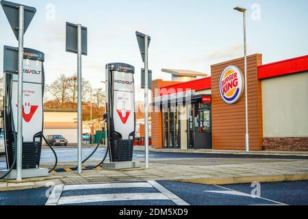 Elektrofahrzeug (EV) Schnellladestelle vor einem Burger King Drive Thru Restaurant, Großbritannien. Stockfoto