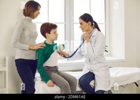 Der Arzt legt ein Stethoskop an die Brust eines Kindes und hört dem Herzschlag und den Lungen des kleinen Jungen zu. Stockfoto