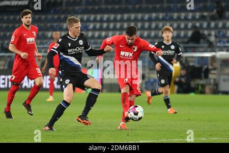 Bielefeld, Deutschland. Dezember 2020. Fußball: Bundesliga, Arminia Bielefeld - FC Augsburg, Matchday 12 in der Schüco Arena. Bielefelds Joakim Nilsson (l) kämpft mit dem Augsburger Marco Richter um den Ball. Quelle: Friso Gentsch/dpa - WICHTIGER HINWEIS: Gemäß den Bestimmungen der DFL Deutsche Fußball Liga und/oder des DFB Deutscher Fußball-Bund ist es untersagt, im Stadion und/oder des Spiels aufgenommene Fotos in Form von Sequenzbildern und/oder videoähnlichen Fotoserien zu verwenden oder zu verwenden./dpa/Alamy Live News Stockfoto