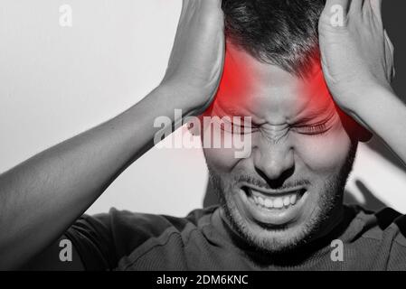 Portrait of young man suffering from painful migraine or strong tension headache Stockfoto