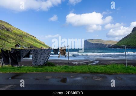 Viðareiði auf der Insel Viðoy, Region Norðoyar, Insel Färöer: Saubere Wäsche, die an einer Wäscheleine hängt, an einem malerischen Ort, der von Bergen umgeben ist. Stockfoto