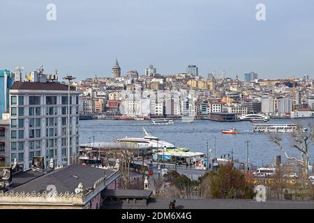 Istanbul, Türkei - 14. Februar 2020: Stadtbild mit Blick auf Vergnügungsboote in der Golden Horn Bucht und Galata Gegend im Beyoglu Bezirk, wolkiger Wintertag Stockfoto