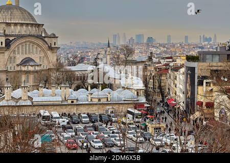 Istanbul, Türkei - 14. Februar 2020: Nuruosmaniye Moschee mit großem Parkplatz vor und Stadtbild in der Ferne, Fatih Bezirk. Stockfoto