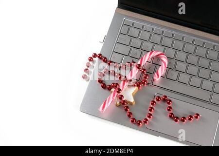 Weihnachtsdekoration und Süßigkeiten auf einem Laptop, Urlaub Online-Shopping während der Coronavirus-Pandemie, weißer Hintergrund mit Kopierraum, Hochwinkel vi Stockfoto