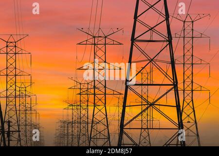 Drei Reihen von Stromtürmen mit Sonnenaufgangshimmel in Los Angeles, Kalifornien. Stockfoto