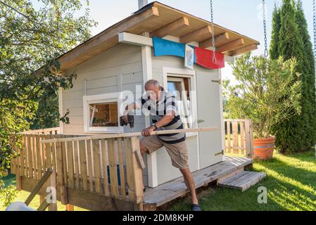 Handwerker baut EINE stabile Holzhütte im Garten Stockfoto