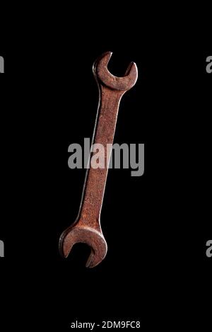 Altes rostiger Schraubenschlüssel-Werkzeug auf schwarzem Hintergrund Stockfoto