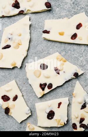 Zerbrochene Stücke von weißer Schokoladenrinde mit Cranberry und Macadamia Mutter Stockfoto