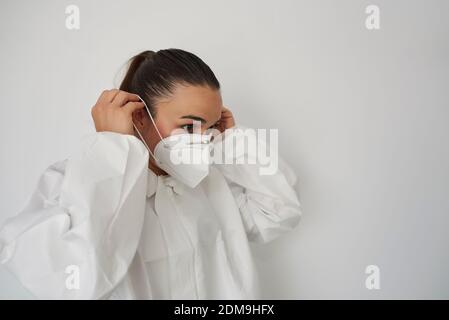 Porträt einer Physiotherapeutin in ihrer Klinik. Der Arzt zieht Schutzkleidung gegen Corona-Virus an. Stockfoto