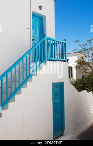 Blau bemalte hölzerne Eingangstüren und Treppen mit Geländer auf traditionellen griechischen Haus, Mykonos-Stadt, Mykonos-Insel, Griechenland. Stockfoto