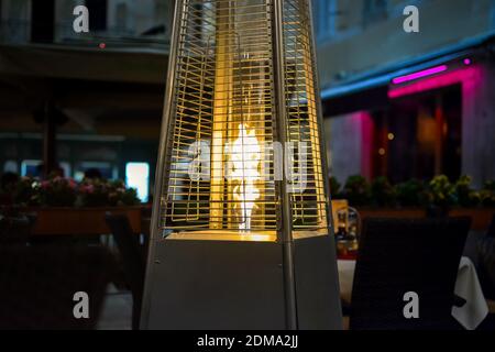 Die Flamme aus einer Terrasse Heizung erwärmt einen kleinen Außenpool, Sidewalk Cafe spät in der Nacht in Split Kroatien Stockfoto